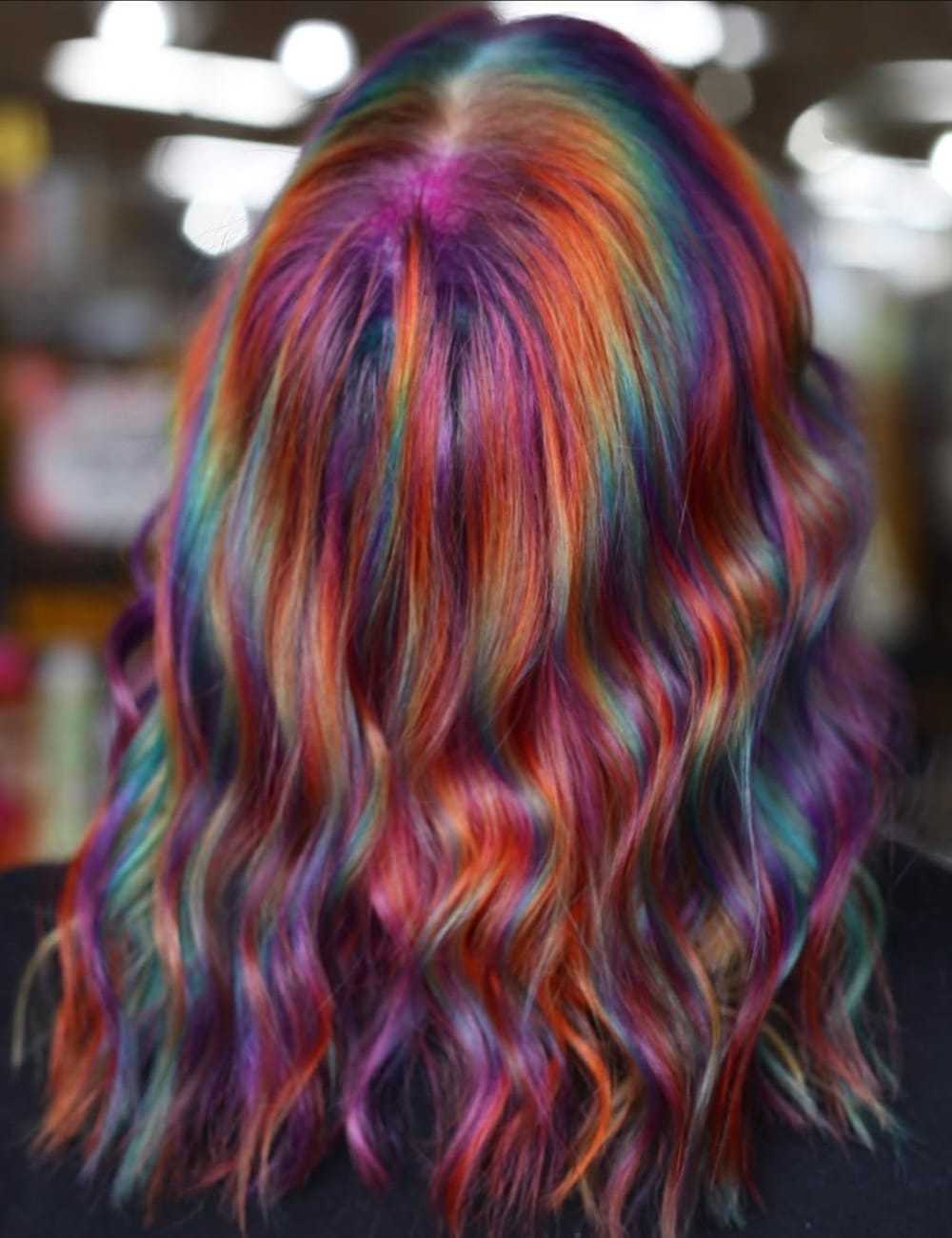 Wavy hair dyed in vibrant rainbow colors.